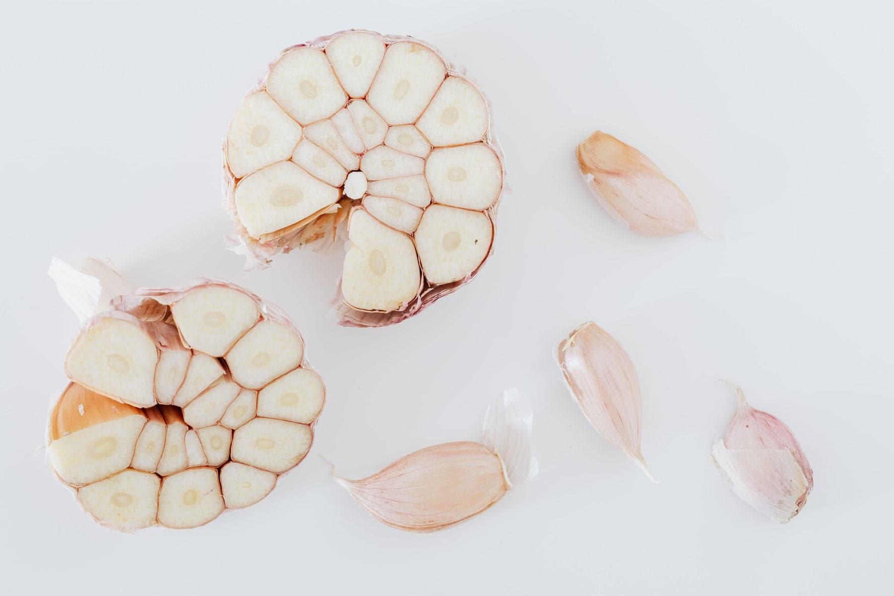 Garlic bulbs cut across, with loose peeled cloves