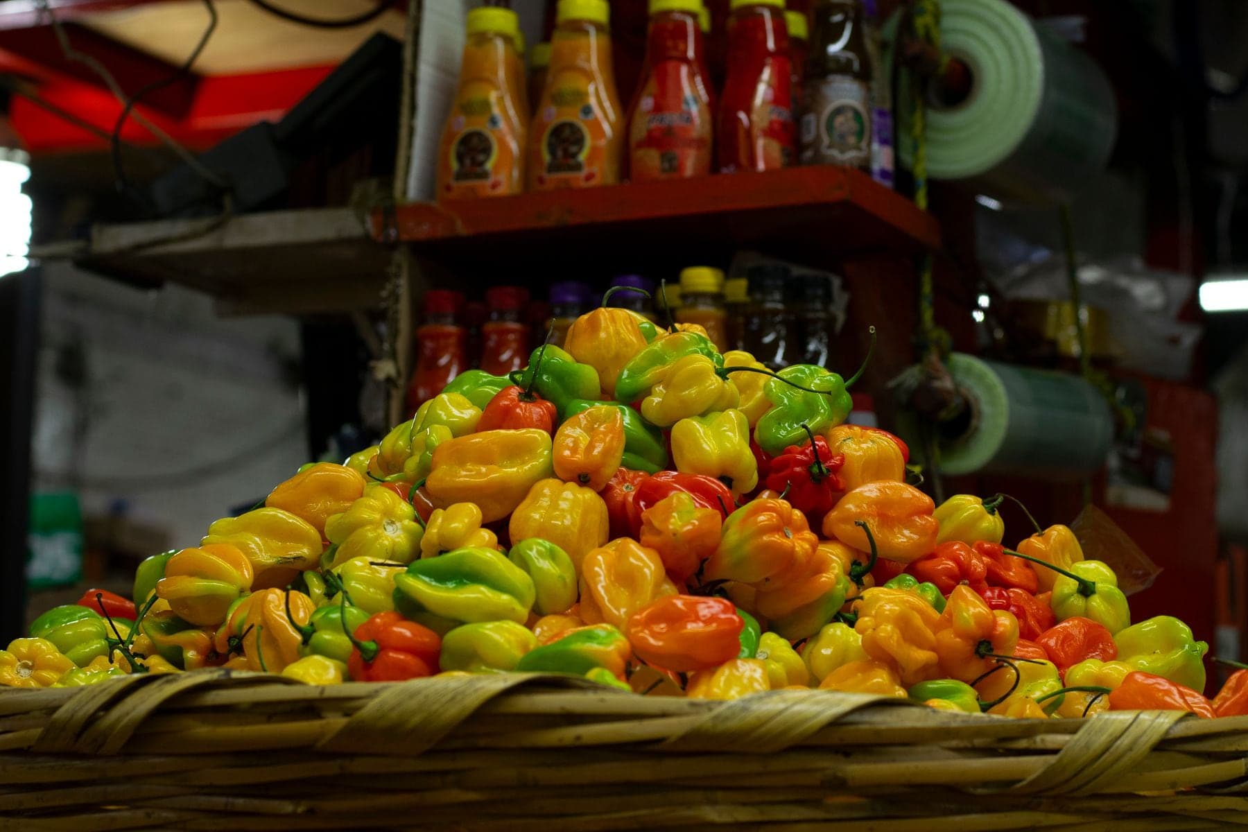 A basket heaped with red, yellow and green seasoning peppers