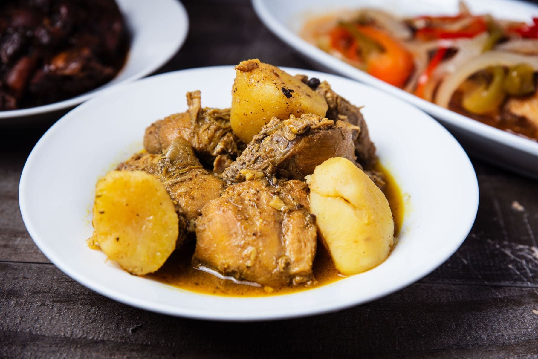 Curry chicken with chunks of potato in a white bowl