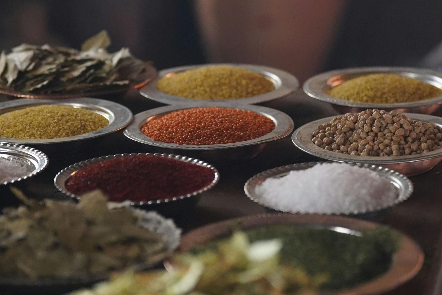 Small metal dishes of ground spices, salt and dried herbs